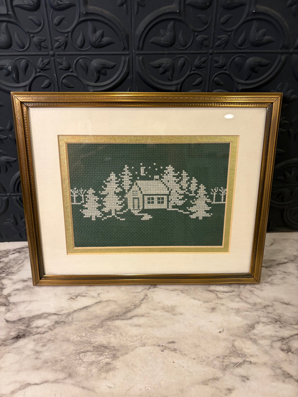 White Cross Stitch on Green of Trees and Cabin