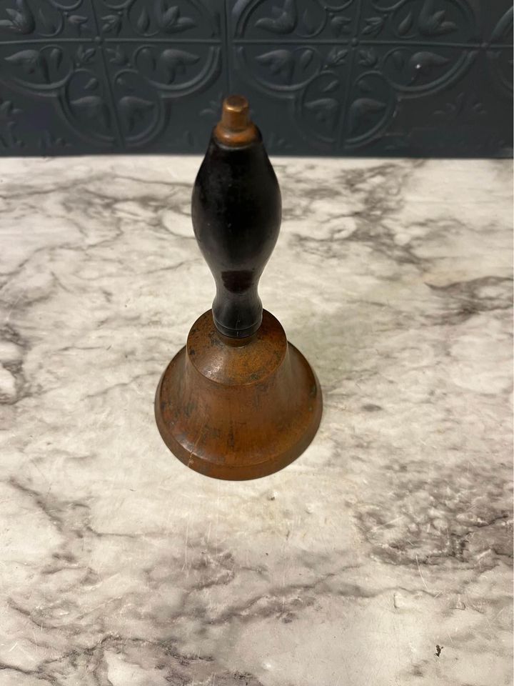 brass bell with black handle