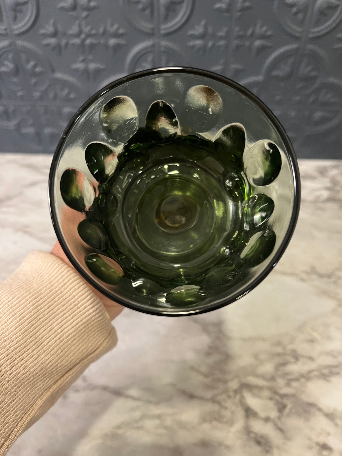 Green glass cup on cast metal base