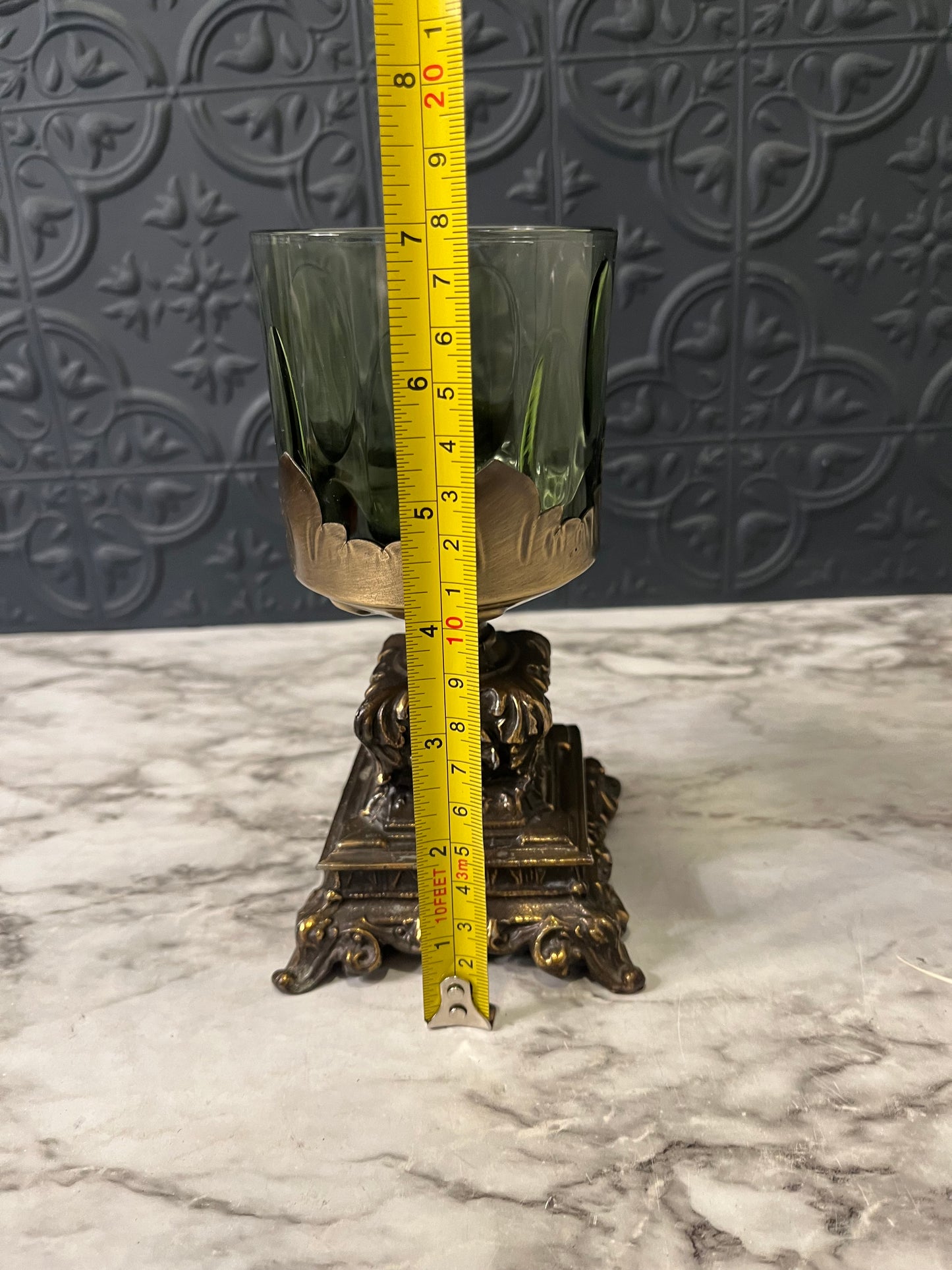 Green glass cup on cast metal base