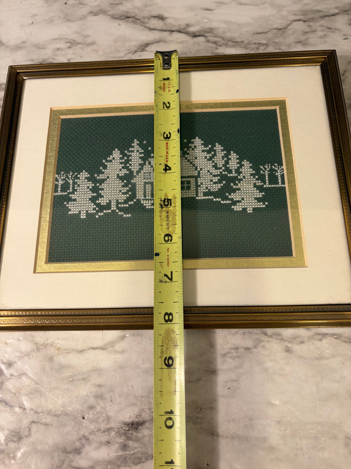 White Cross Stitch on Green of Trees and Cabin