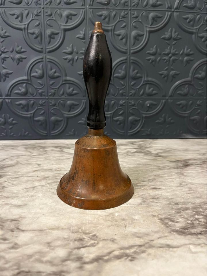 brass bell with black handle