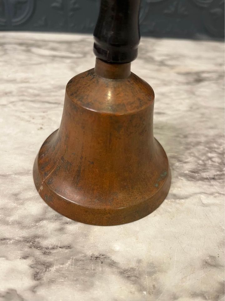 brass bell with black handle