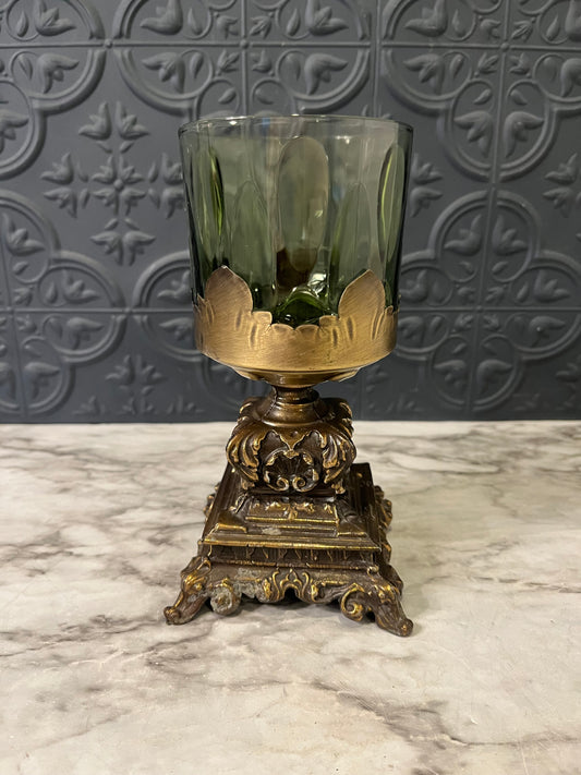 Green glass cup on cast metal base