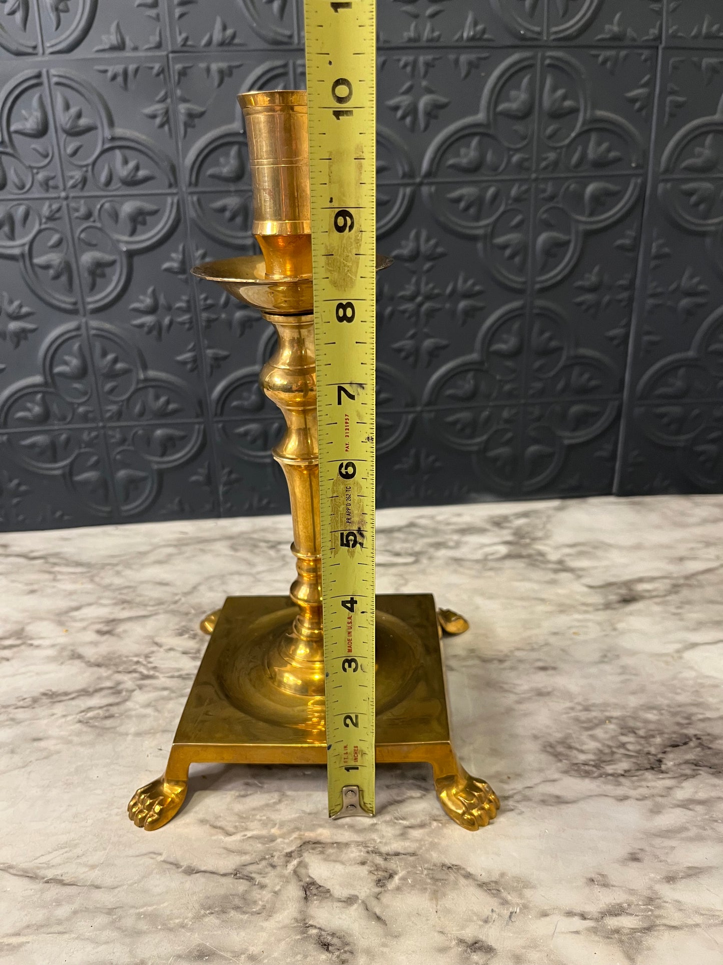 Brass candlestick with square base and feet