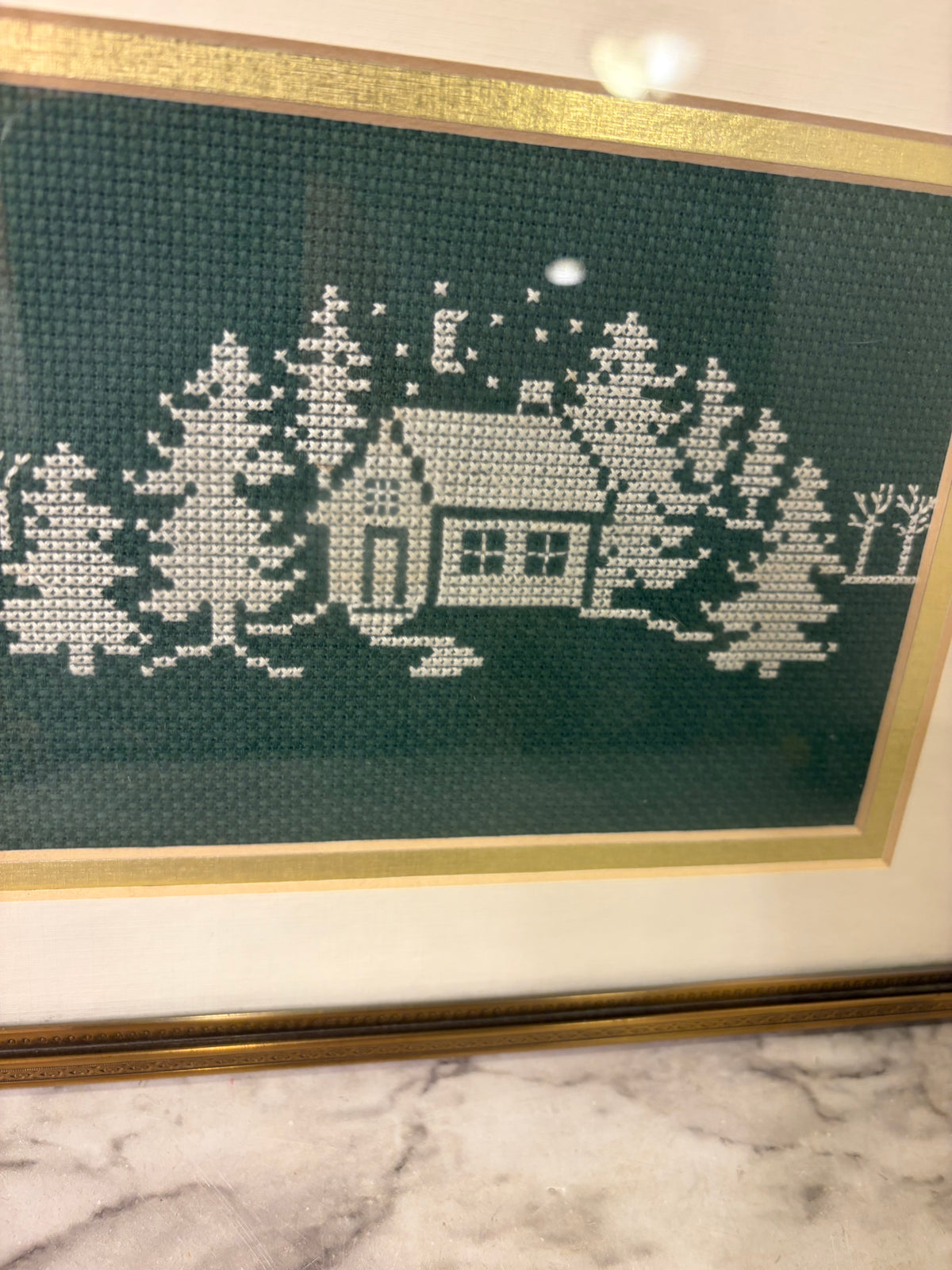 White Cross Stitch on Green of Trees and Cabin