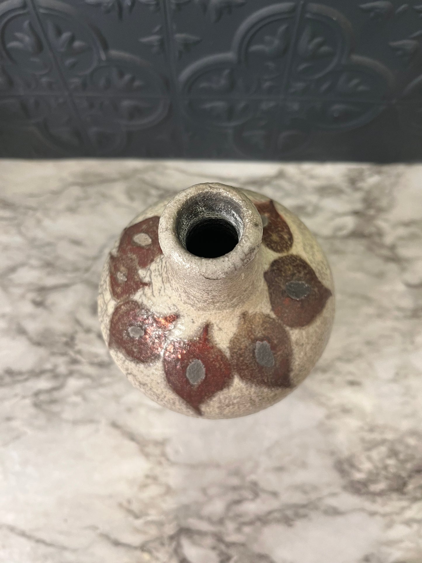 Pottery vase with leaf design around top