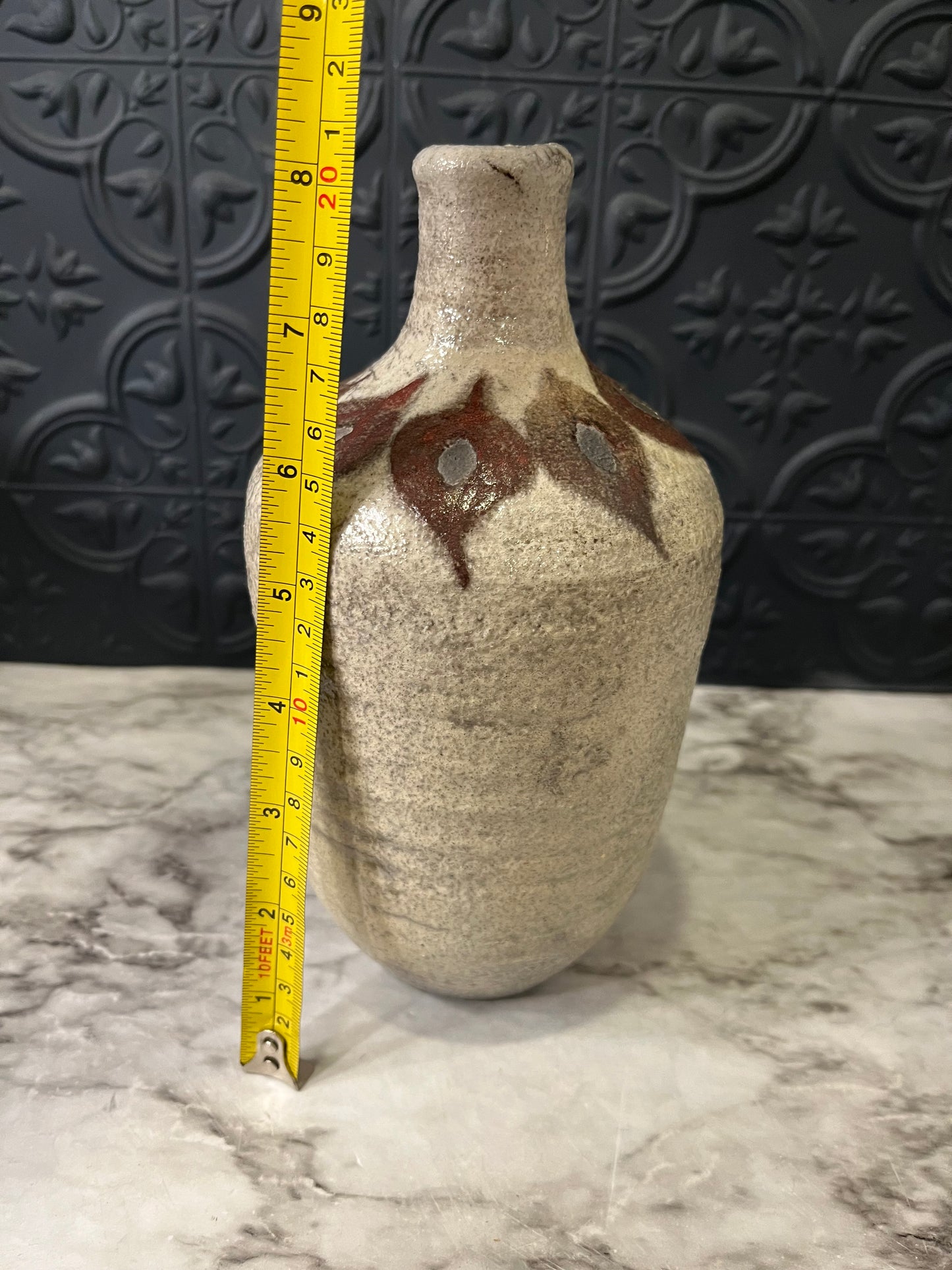 Pottery vase with leaf design around top