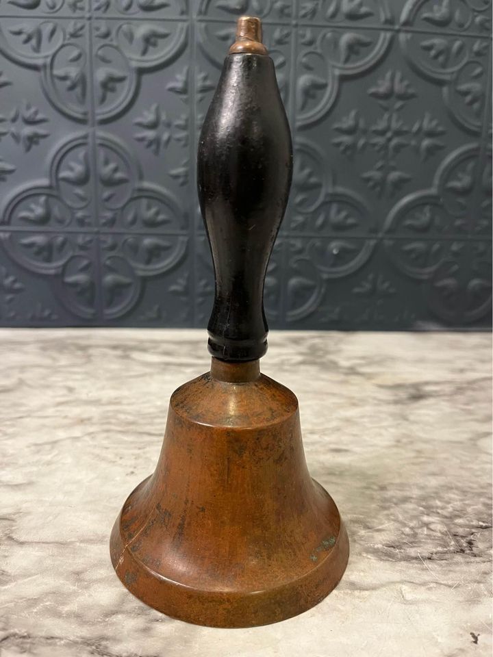 brass bell with black handle